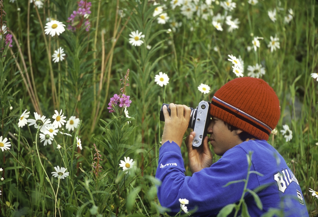 Young man photographing flowers